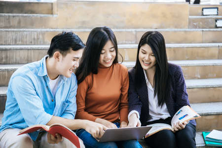 Group students studying researching on laptop Together sitting at college.の写真素材