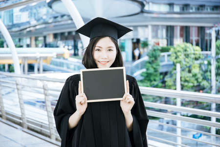 Graduate Woman Holding with blackboard.の写真素材