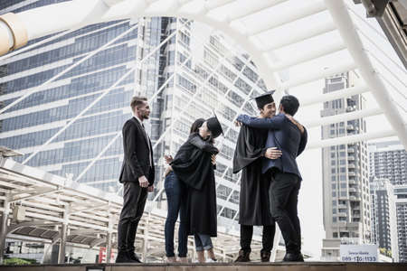 Happy international students and bachelor gowns with diplomas.の写真素材