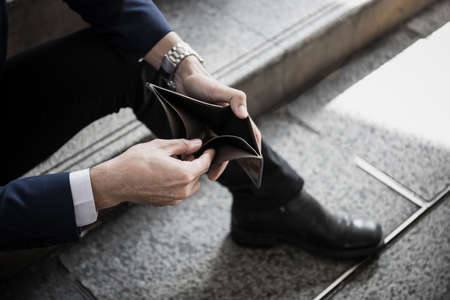 Close up of Businessman holding an empty wallet in his hands.
