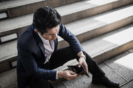 Close up of Businessman holding an empty wallet in his hands.