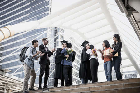 Asian students graduate being congratulated by their parent at graduation ceremonyの写真素材