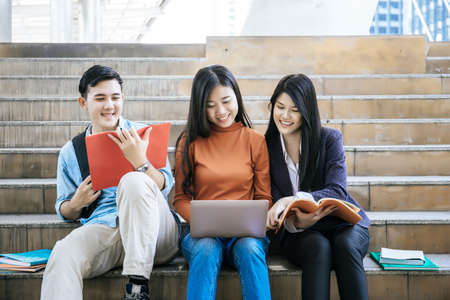 Group students studying researching on laptop Together sitting at college.の写真素材