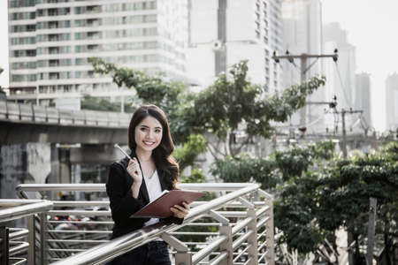 Young business woman holding reports and looking at camera.の写真素材