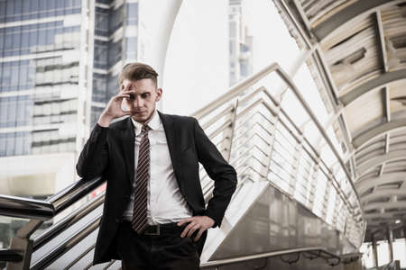 Young business man to think and not Work with stress Pretending to put his hand to the head feeling so disappointed.の写真素材