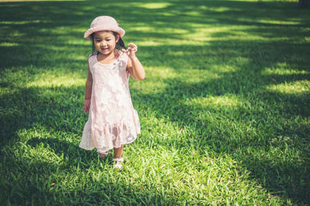 Little girl walking alone in a park or forest
