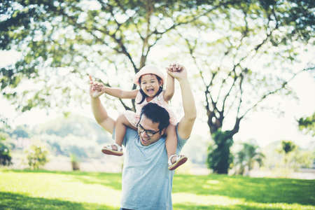 Father gives her daughter piggyback, happy time family.の写真素材