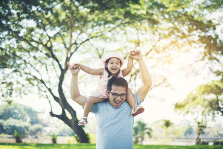 Father gives her daughter piggyback, happy time family.の写真素材