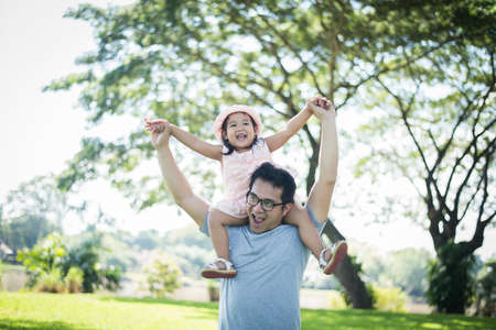 Father gives her daughter piggyback, happy time family.の写真素材