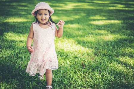 Little girl walking alone in a park or forestの写真素材