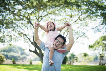 Father gives her daughter piggyback, happy time family.の写真素材