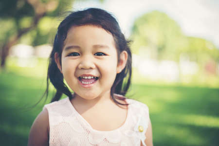 Portrait of little girl smiling showing happy in the park