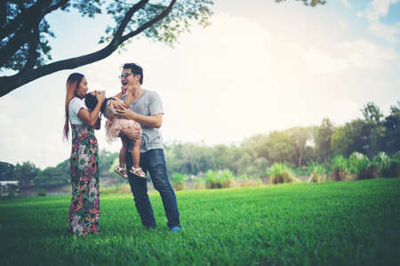 Happy family in the park, Father and Mother playing with daughter, relax family timeの写真素材