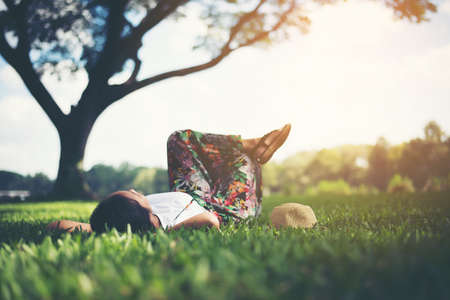 Young woman lying down on grass. relax time.の写真素材
