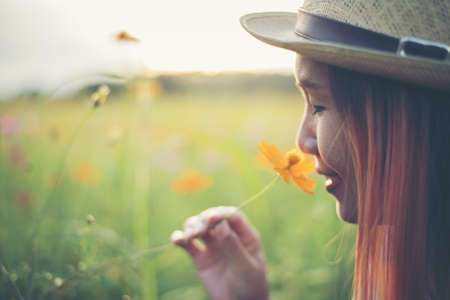 Young cute woman smelling yellow flowersの写真素材