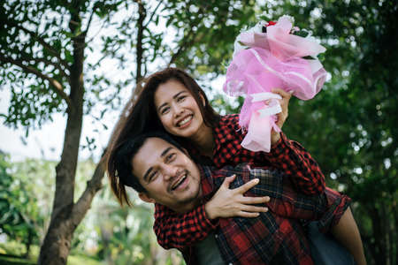 Close-up of a man giving happy woman flowers.A picture of a romantic couple getting.の写真素材