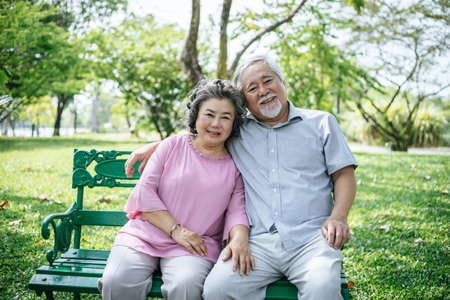 healthy senior couple relaxing  seats on the bench in the parkの写真素材