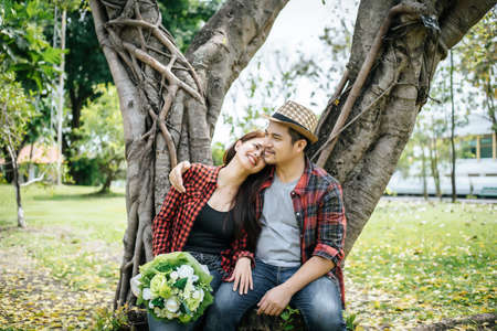 Close-up of a man giving happy woman flowers.A picture of a romantic couple getting.の写真素材