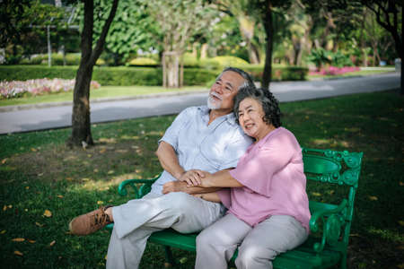 healthy senior couple relaxing  seats on the bench in the parkの写真素材