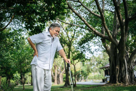 Old man with cane suffering from back painの写真素材
