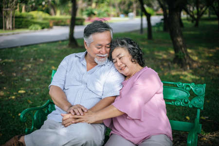healthy senior couple relaxing  seats on the bench in the parkの写真素材