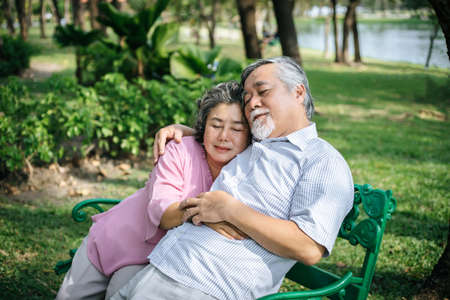 healthy senior couple relaxing  seats on the bench in the parkの写真素材