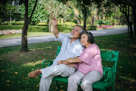 healthy senior couple relaxing  seats on the bench in the parkの写真素材