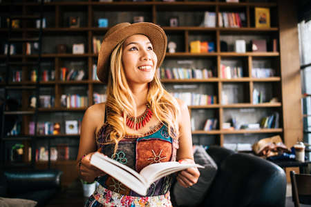 Young woman  reading book and fresh cup of coffee on the tableの写真素材