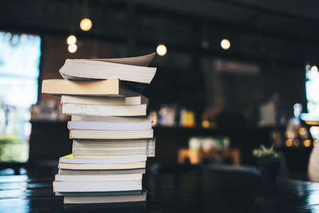 Composition with stack of books on table in cafeの写真素材