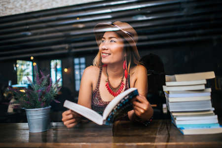 Young woman  reading book and fresh cup of coffee on the tableの写真素材