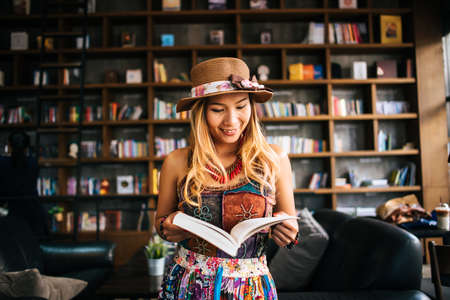 Young woman  reading book and fresh cup of coffee on the tableの写真素材