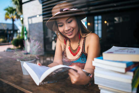 Young woman  reading book and fresh cup of coffee on the tableの写真素材