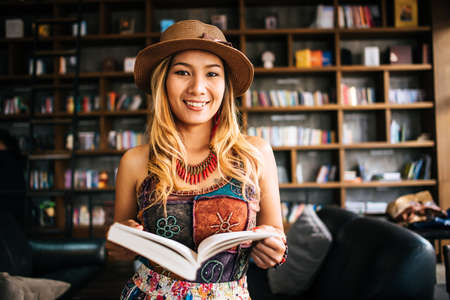 Young woman  reading book and fresh cup of coffee on the tableの写真素材