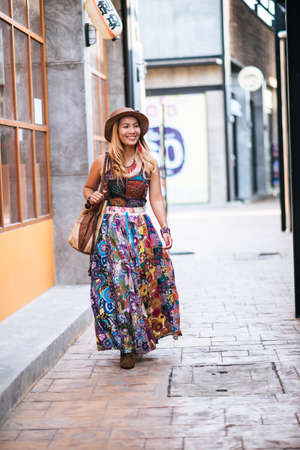 The woman is walking on the street with great smile.の写真素材