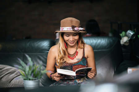 Young woman  reading book and fresh cup of coffee on the tableの写真素材
