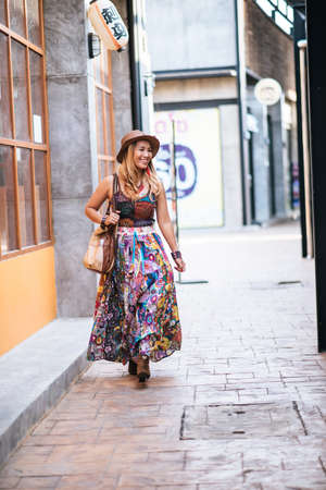 The woman is walking on the street with great smile.の写真素材