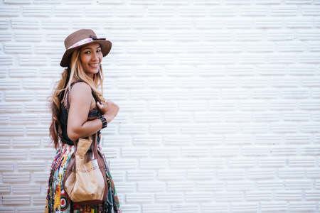 woman wearing white t-shirt against brick wallの写真素材