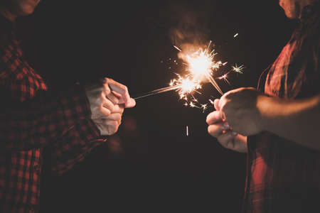 The happy couple hold a firework sticks. evening night timeの写真素材