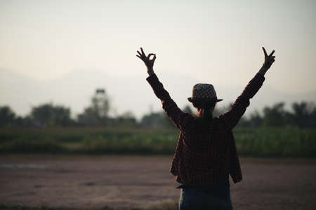 Silhouette of free woman enjoying freedom feeling happy at sunset. Serene relaxing woman in pure happinessの写真素材