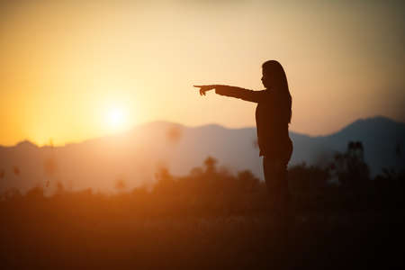 Silhouette of woman praying over beautiful sky backgroundの写真素材
