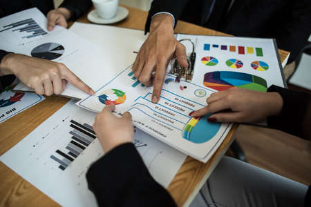 Close up of business people working with business document during discussion at meeting.の写真素材
