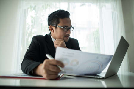 Young businessman working with laptop at officeの写真素材
