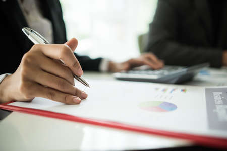 Close up of business people working with business document during discussion at meeting.の写真素材