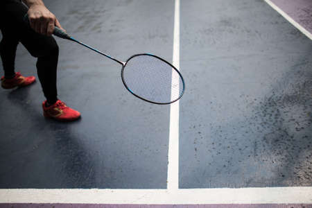 Young man playing badminton outdoorsの写真素材