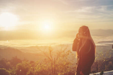 woman is listening to music on Mountainの写真素材