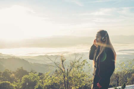 woman is listening to music on Mountainの写真素材