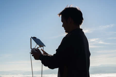 Young navigating a flying drone with remote control
