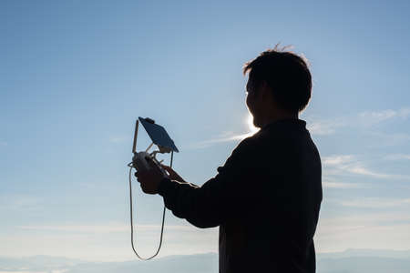Young navigating a flying drone with remote controlの写真素材