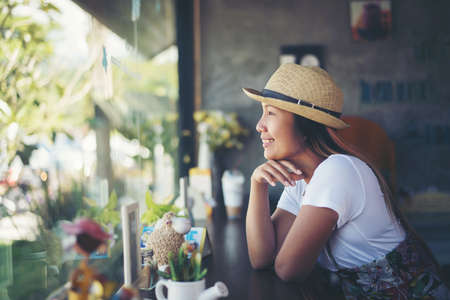 Beautiful cute girl in the cafe near the window with coffee smilingの写真素材