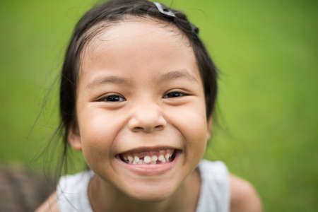 Close up of cute little girl's face with a smile looking at the camera.の写真素材